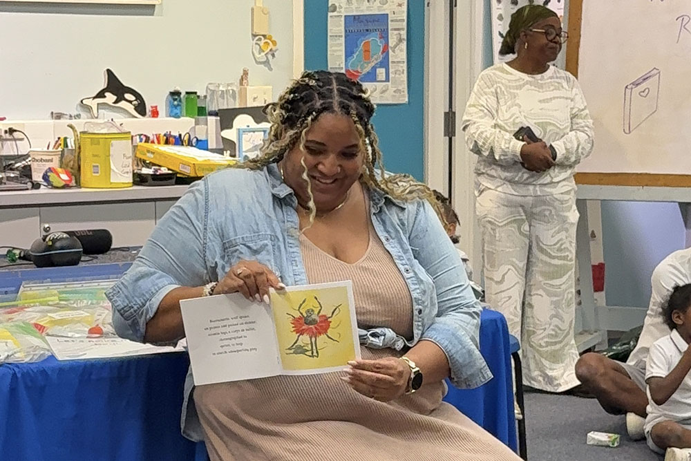 Colleague reading to students as Fortitude Re donates $50,000 to Bermuda Education Network to support youth education